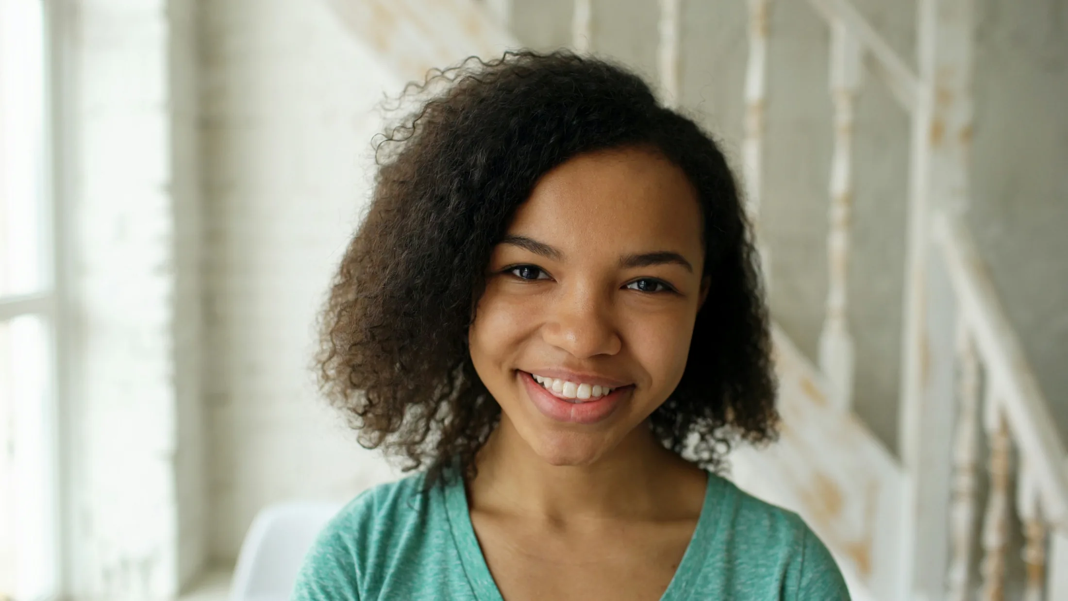 Young woman with curly textured hair smiling